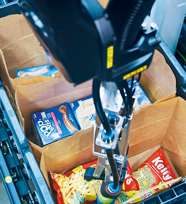 Pick-it-Easy Robot handling groceries in a food retail environment, demonstrating AI‑driven picking accuracy, gentle item handling, and efficient automation for high‑volume supermarket fulfillment.