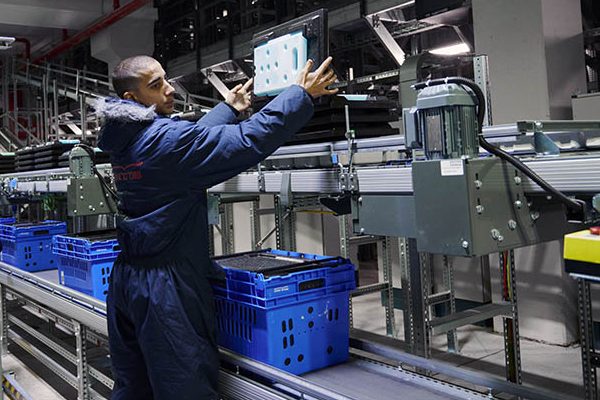 When frozen items are retrieved in the shuttle system, employees add lids with integrated cold packs before items are transported to the shipping area. The insulated containers maintain the cold chain all the way to the consumer.