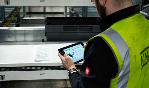 knapp maintenance technician inspecting an automated palletizing system to ensure reliable performance for operations with dynamic business requirements.