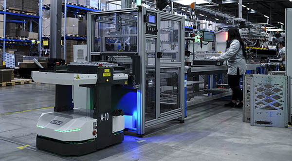 Photograph of an autonomous mobile robot illustrating integrate‑ability, emphasizing how some AMRs rely on non‑standard interfaces that require custom integration, struggle to connect with existing automated warehouse systems, and lack the flexibility to change paths or material flows on demand.