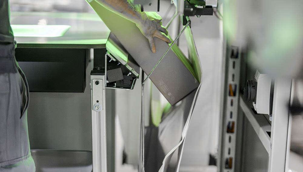 Warehouse associate handling returned items near an automated pocket sorter system, illustrating how rising return volumes and processing costs continue to increase pressure on eCommerce and omnichannel fulfillment operations.