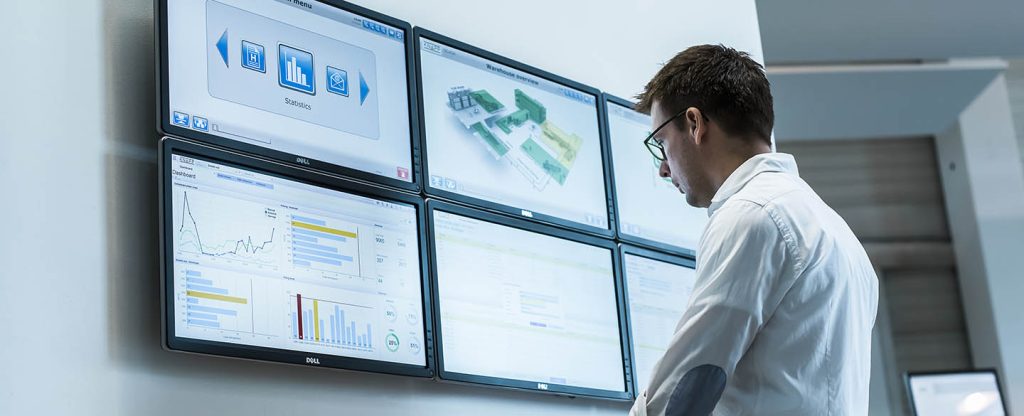 Man analyzing six large operational dashboards to optimize metro‑area distribution, improve responsiveness, and support environmentally responsible replenishment strategies.